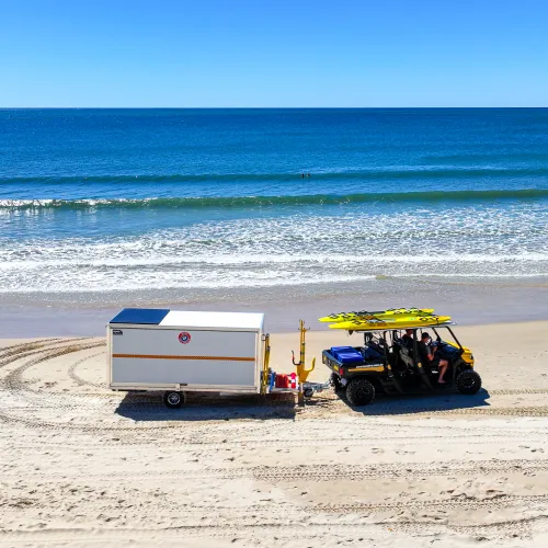 Beach four wheeler towing aluminium surf club trailer